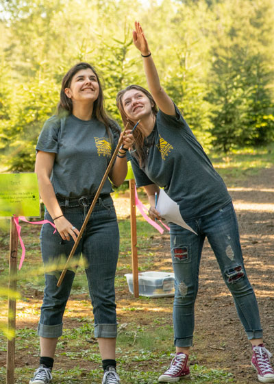 Two girls working together to plant a tree
